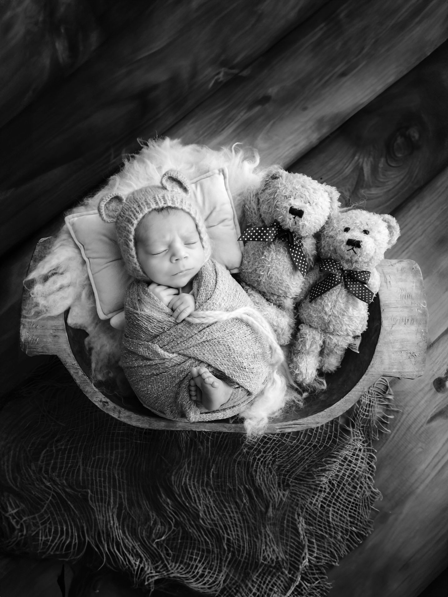 A serene and heartwarming photograph of a newborn baby swaddled in a soft, white blanket, peacefully sleeping on a fluffy, cream-colored rug. The baby's delicate features, tiny hands, and chubby cheeks are captured in natural light, emphasizing the innocence and purity of infancy. The background is softly blurred, bringing the focus to the baby, who is posed in a cozy, curled-up position reminiscent of the womb. This image exudes warmth and tranquility, making it perfect for a newborn photography portfolio, capturing the essence of early childhood in a timeless and tender manner